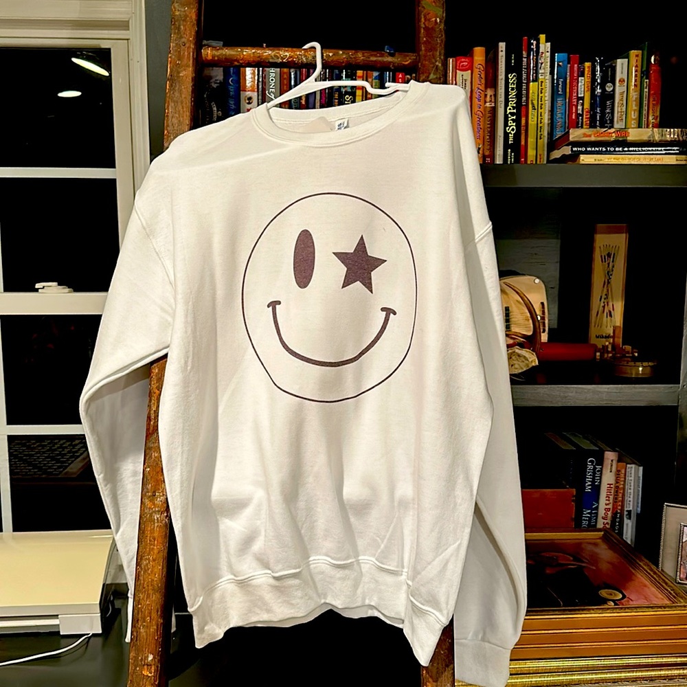 White sweatshirt with smiley face design.